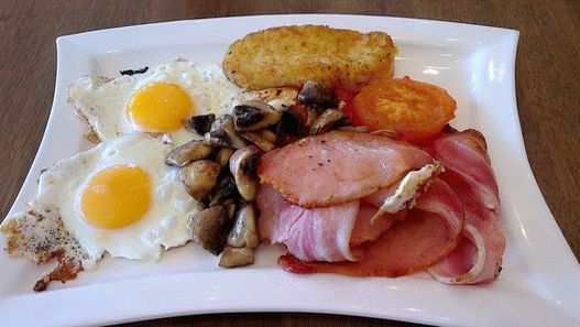 तले हुए अंडे, हैश ब्राउन और बेक्ड टमाटर के साथ फोटो आयरिश नाश्ता