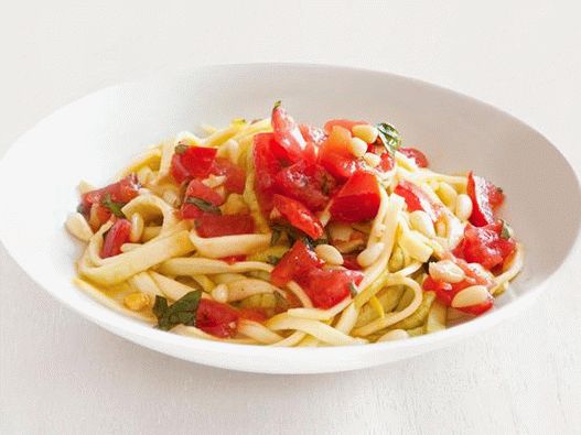 स्लाइस के साथ मसालेदार टमाटर सॉस के साथ ताजा तोरी से पास्ता Fettuccine की तस्वीर